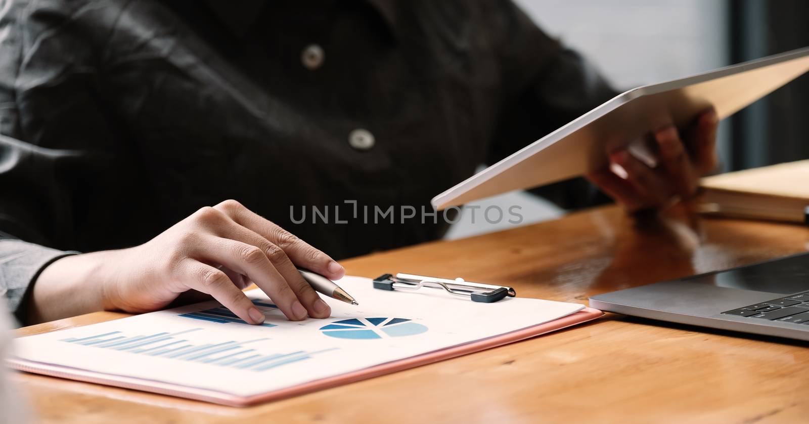 Business woman using tablet computer for analysis financial report.