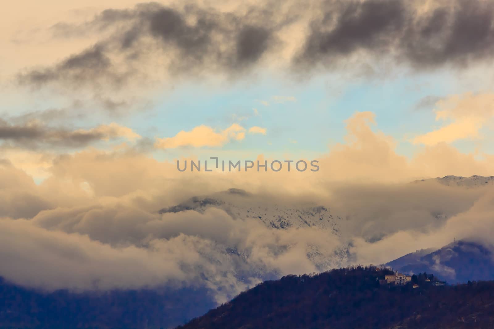 a snowy mountain surrounded by white and dark clouds by moorea