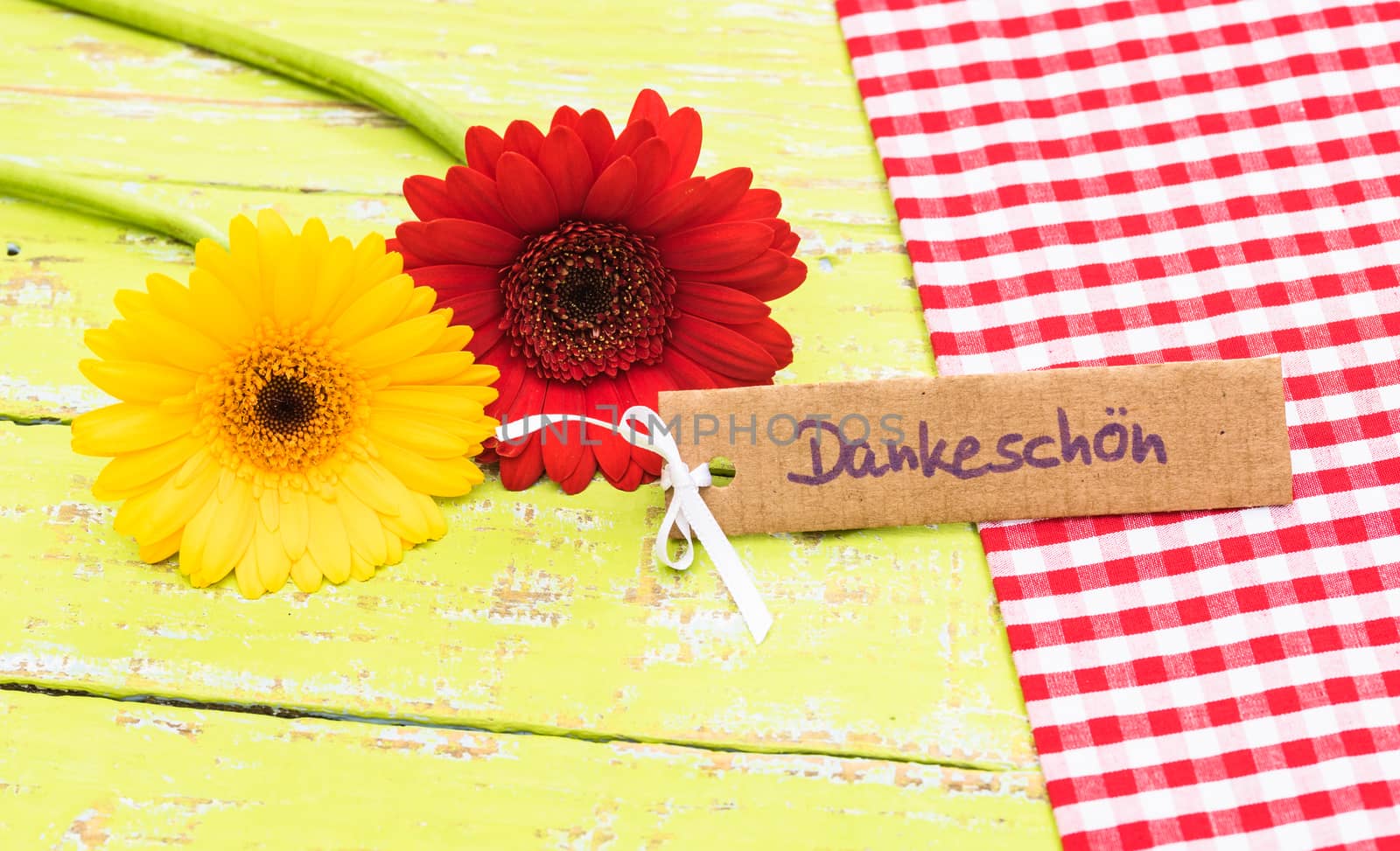 Red and yellow gerbera flowers with card with german word, Dankeschoen, means thanks