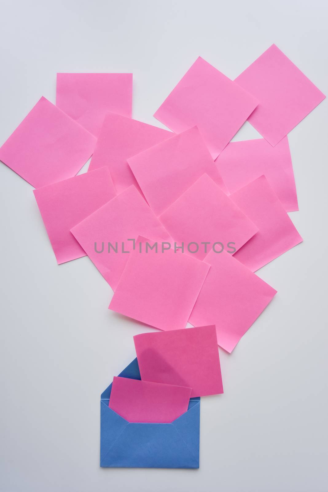 selective focus, pink paper stickers in chaos and blue envelope down on the white background