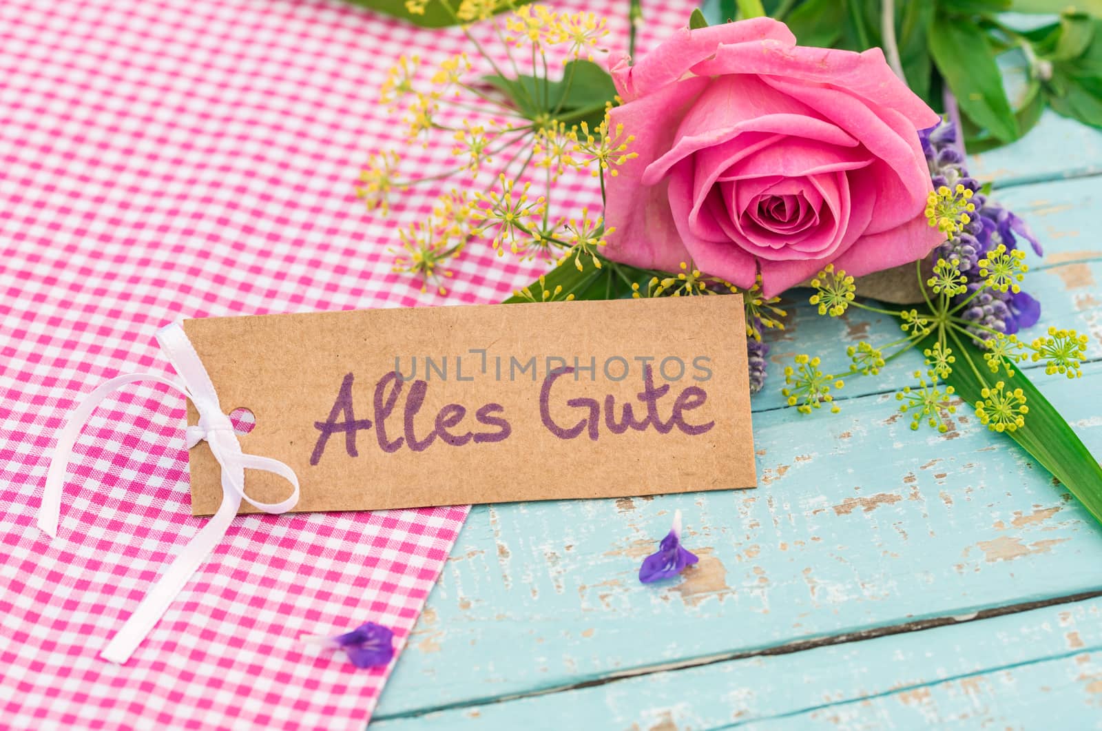 Bouquet of flowers and card with german text, Alles Gute, means best wishes