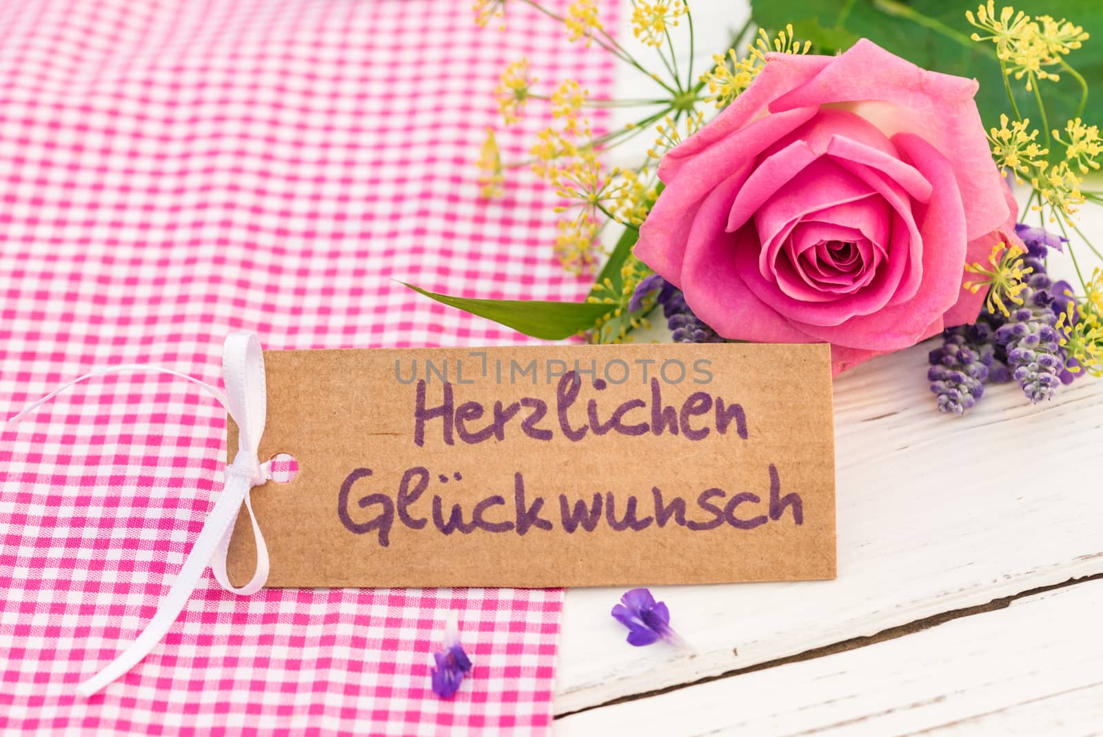 Romantic bunch of flowers and card with german text, Herzlichen Glueckwunsch, means congratulation