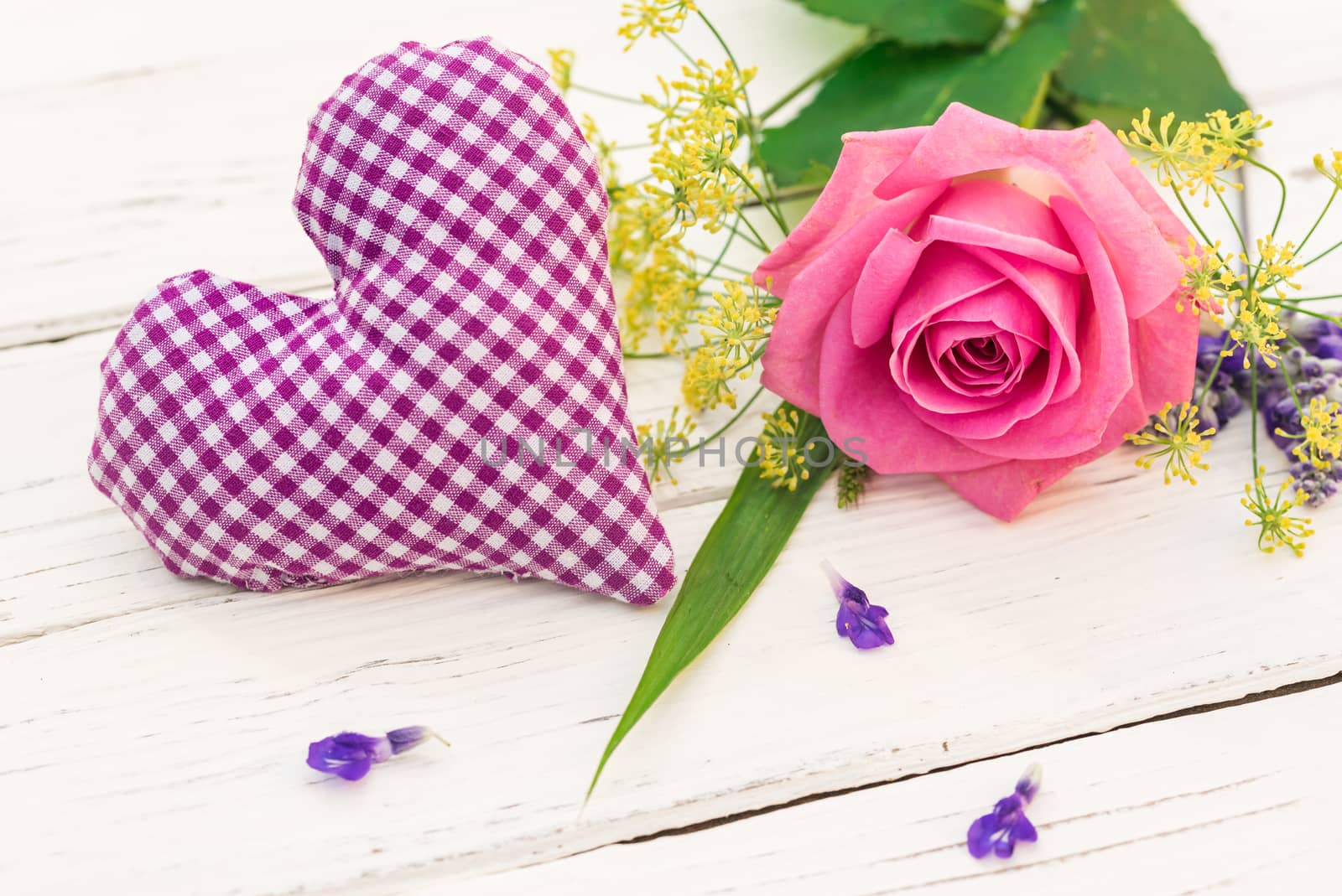 Beautiful bunch of flowers with pink rose and lilac fabric heart on white background