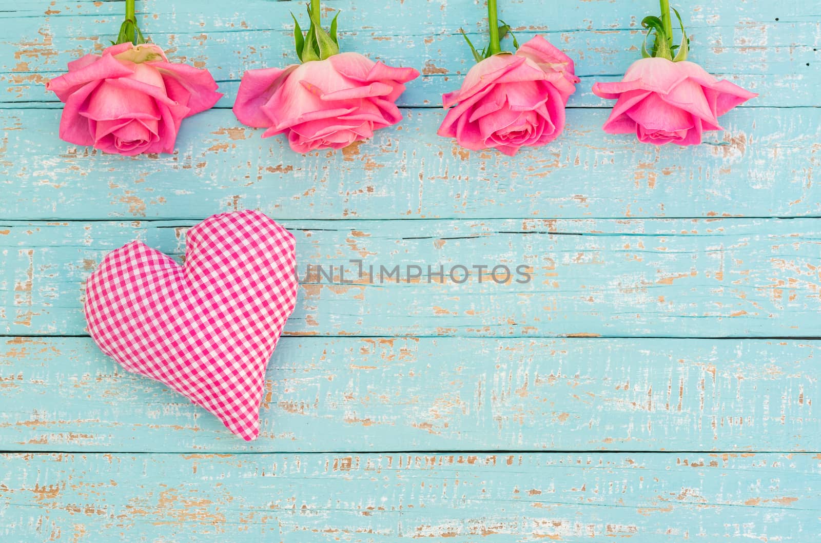 Romantic valentine day background with heart and beautiful fresh pink  roses on light blue wood