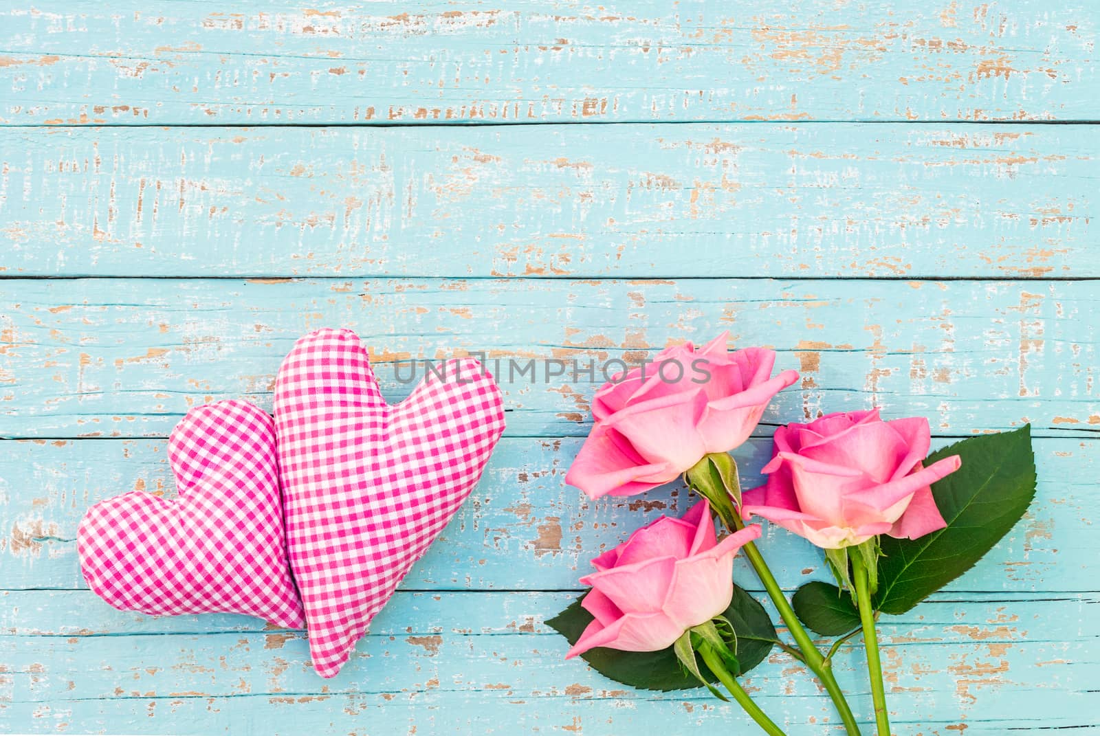 Two pink hearts with bouquet of roses on turquoise wooden background by Vulcano
