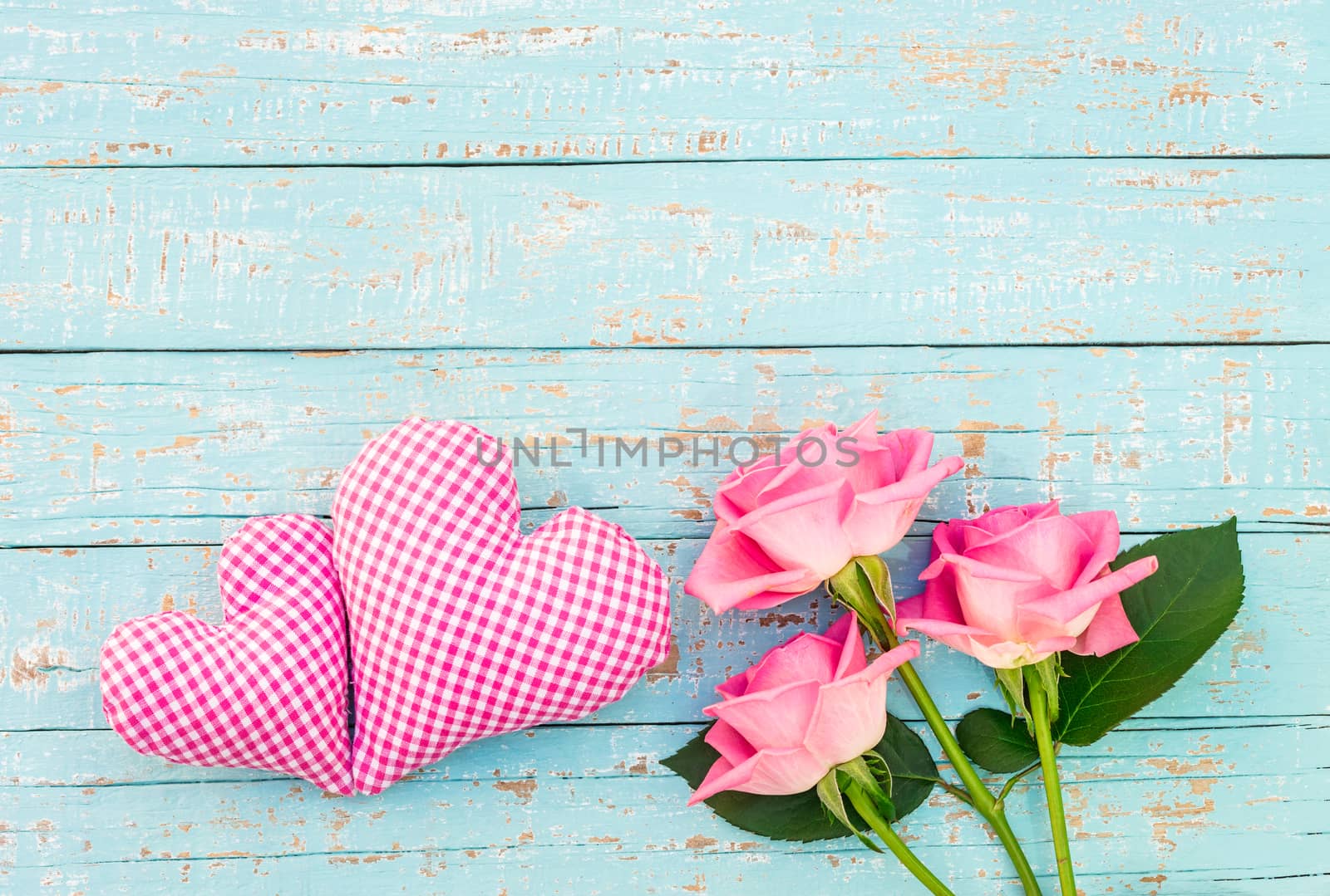 Pink heart and bouquet of pink roses on turquoise wooden background by Vulcano