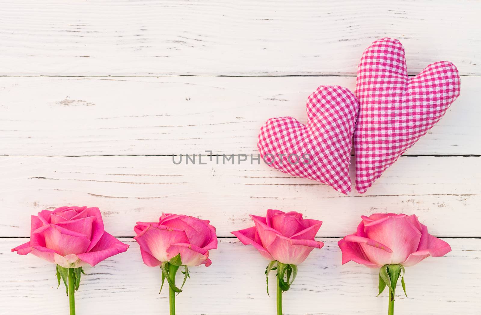 Two pink hearts and roses frame on white wooden background with copy space