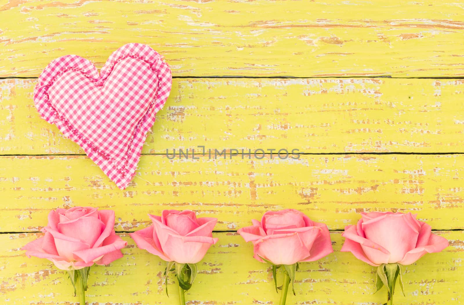Pink love heart and beautiful roses frame on yellow wood with space for text