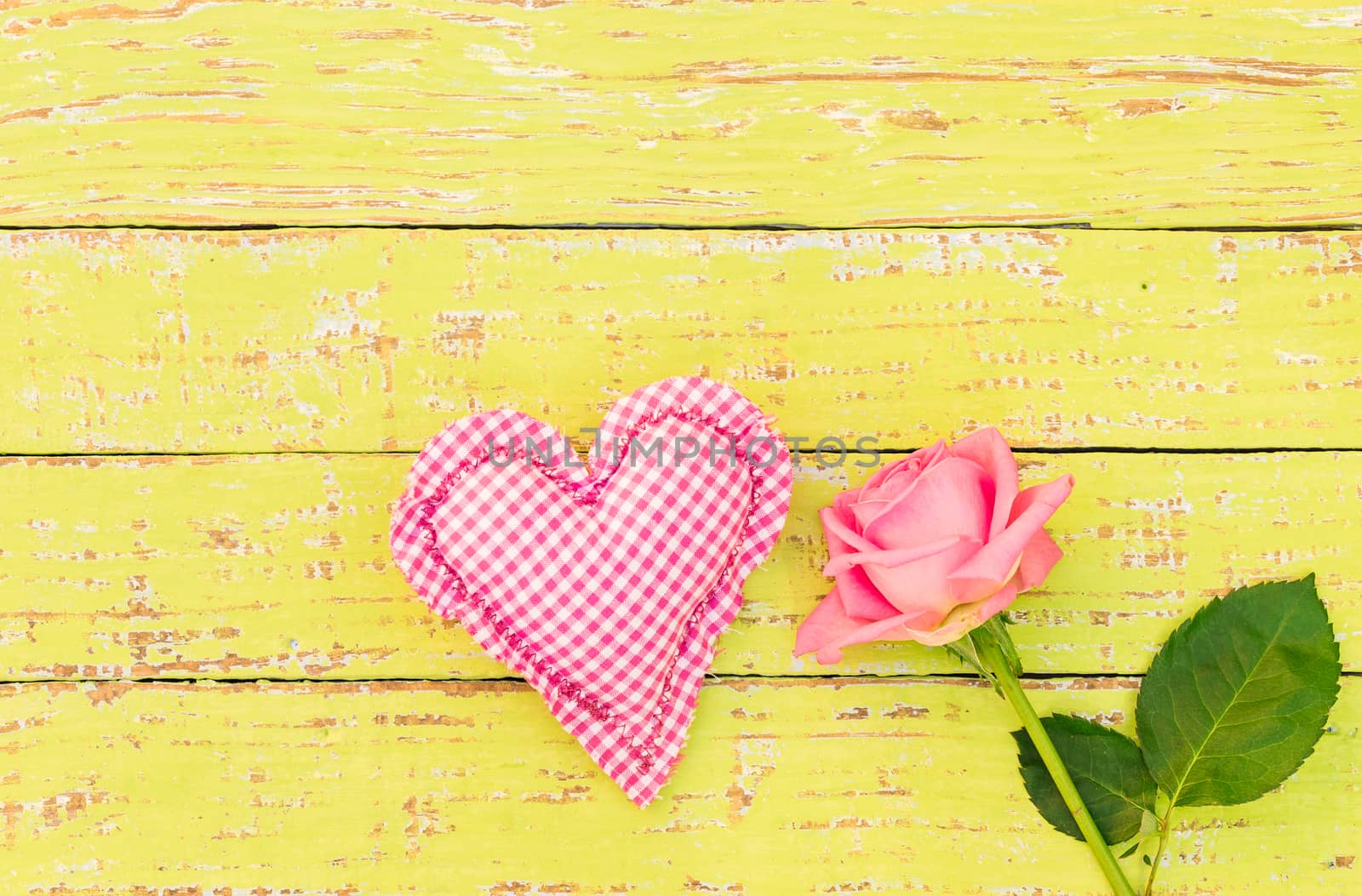 Pink heart and rose flower on yellow wooden background for Mothers day