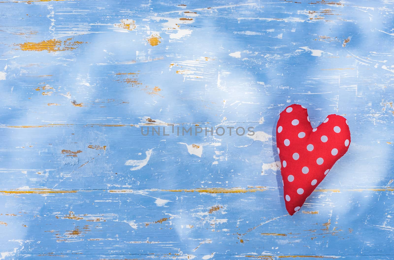 Romantic background with red love heart on blue wood with copy space