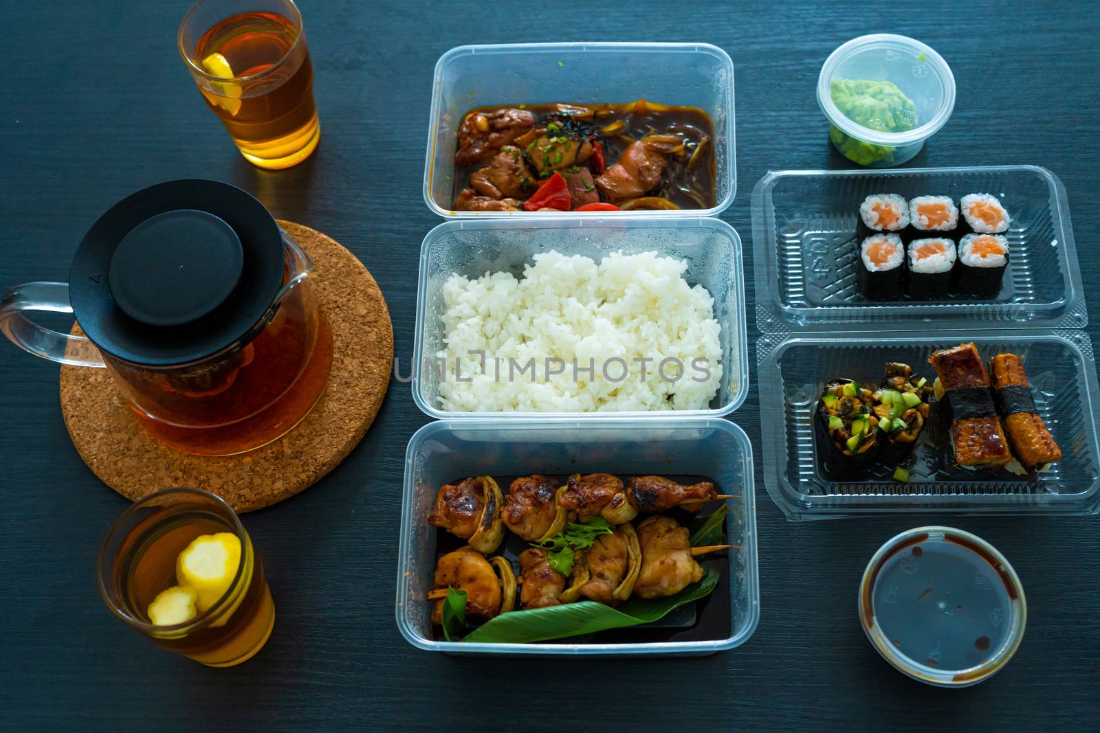 Asian food, sushi, rolls, rice and chicken skewers. Food in disposable dishes. Order Asian Food at Home by Try_my_best