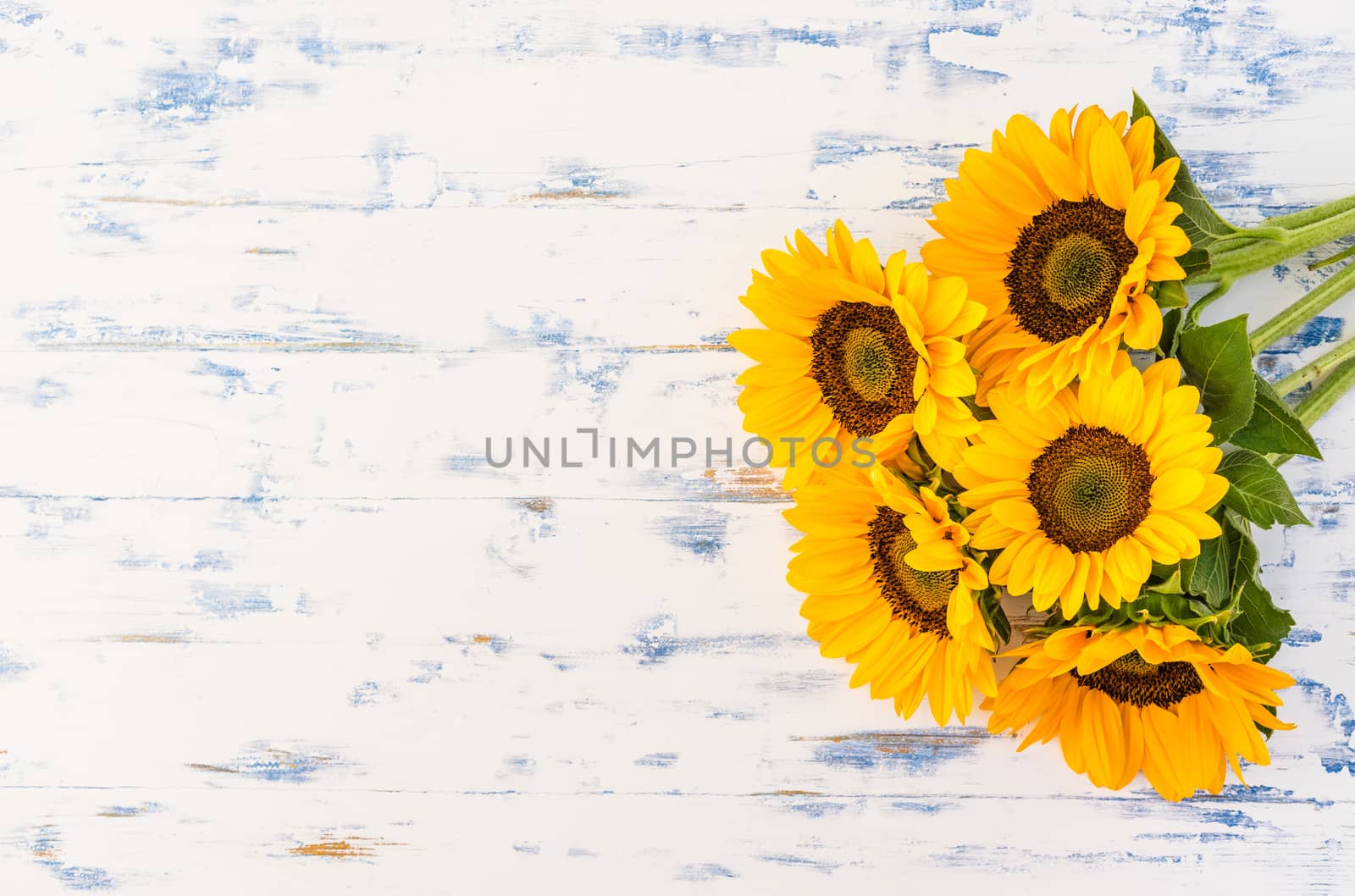 Bouquet of yellow sunflowers on rustic wooden background with copy space