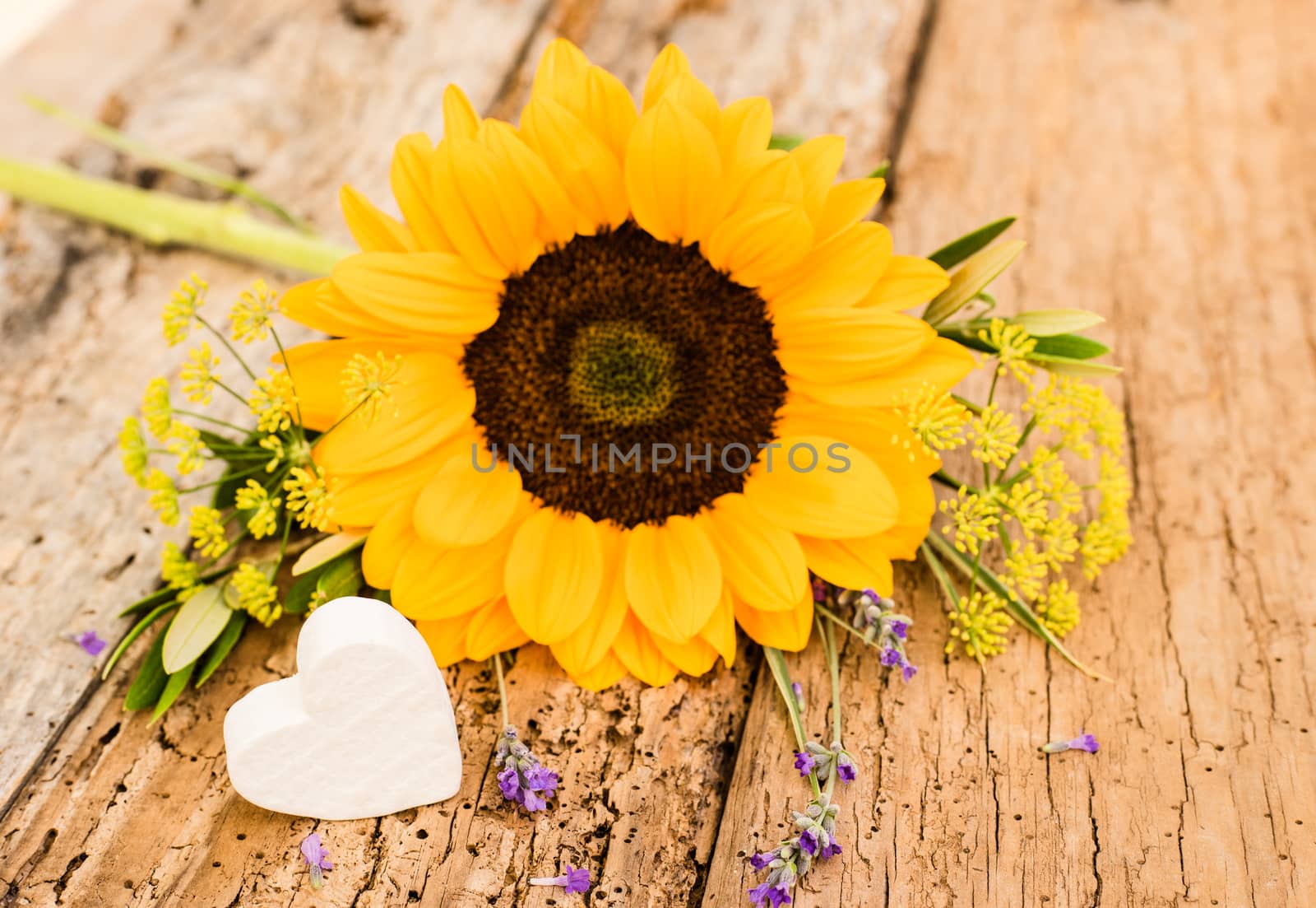 Beautiful bunch of flowers with yellow sunflower and heart on rustic wood