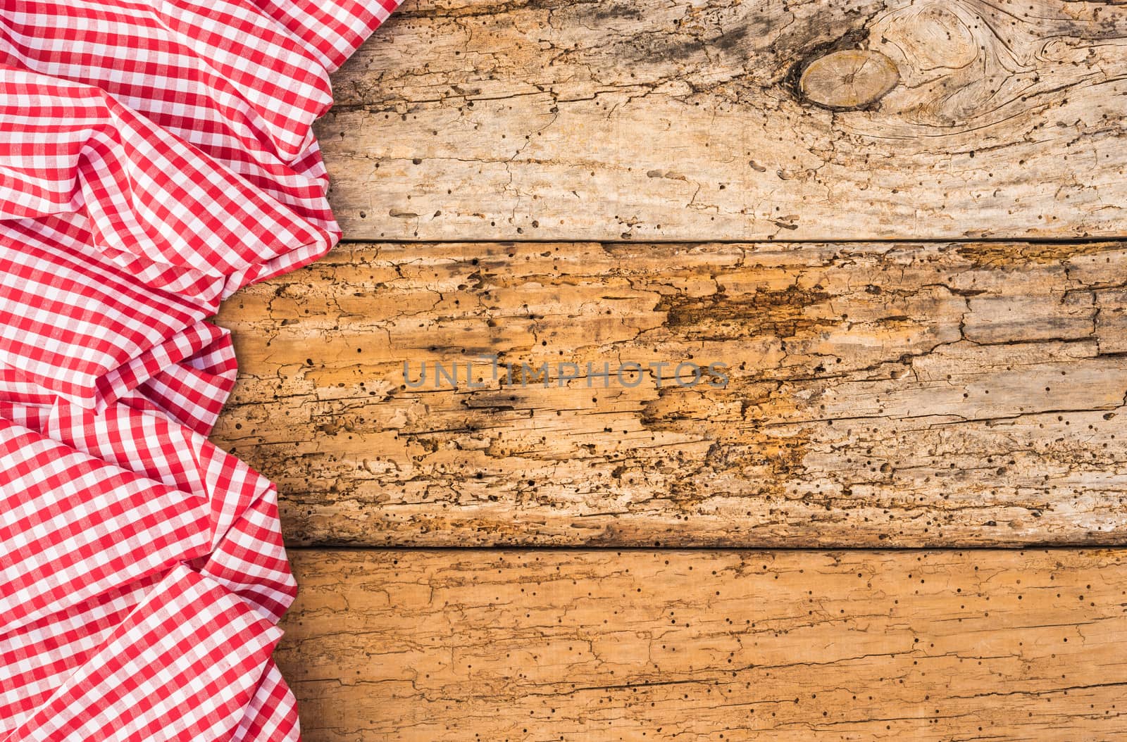 Tablecloth on wooden table, food background, red checked fabric, top view, copy space