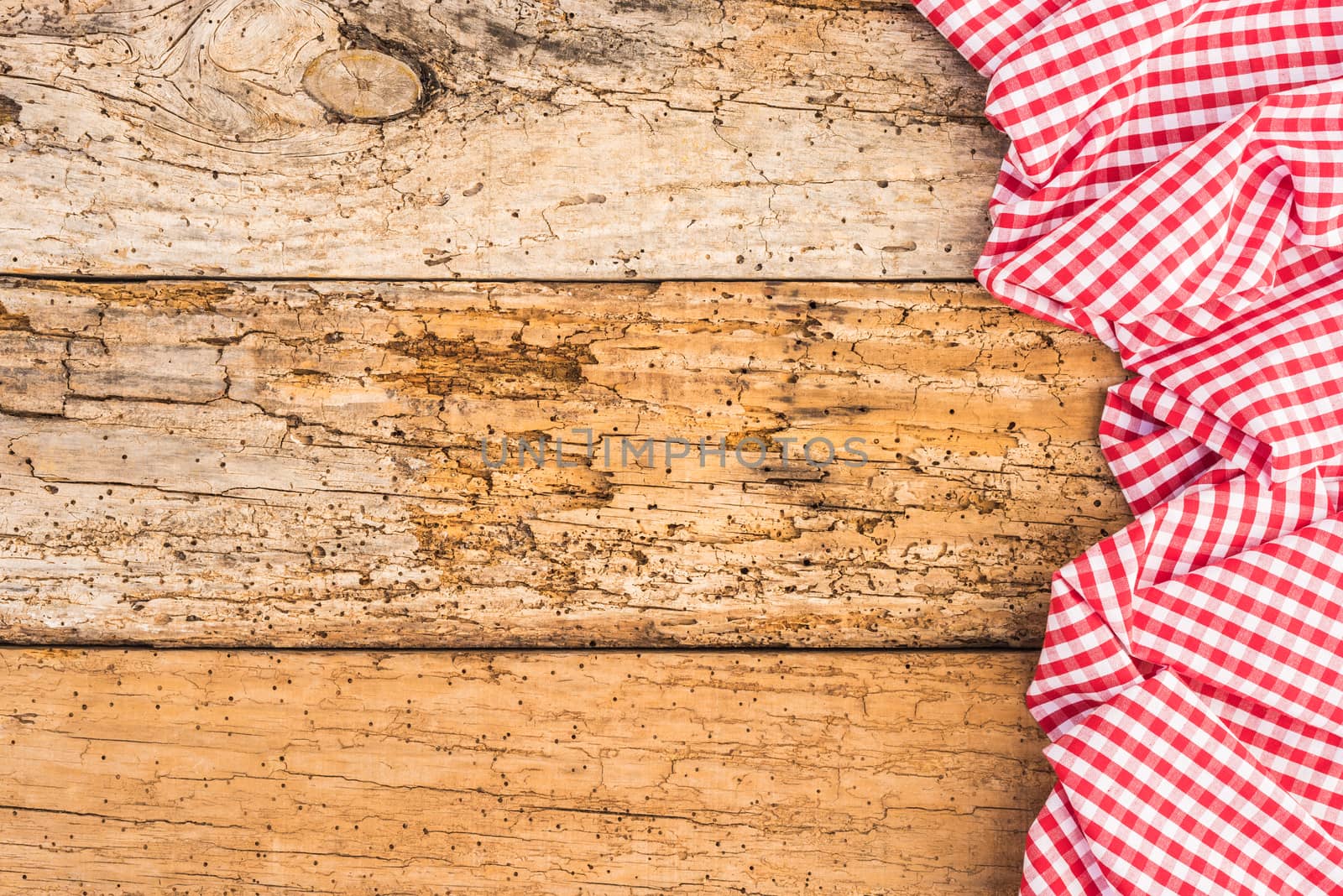 Red checked table cloth on old rustic wood background with copy space