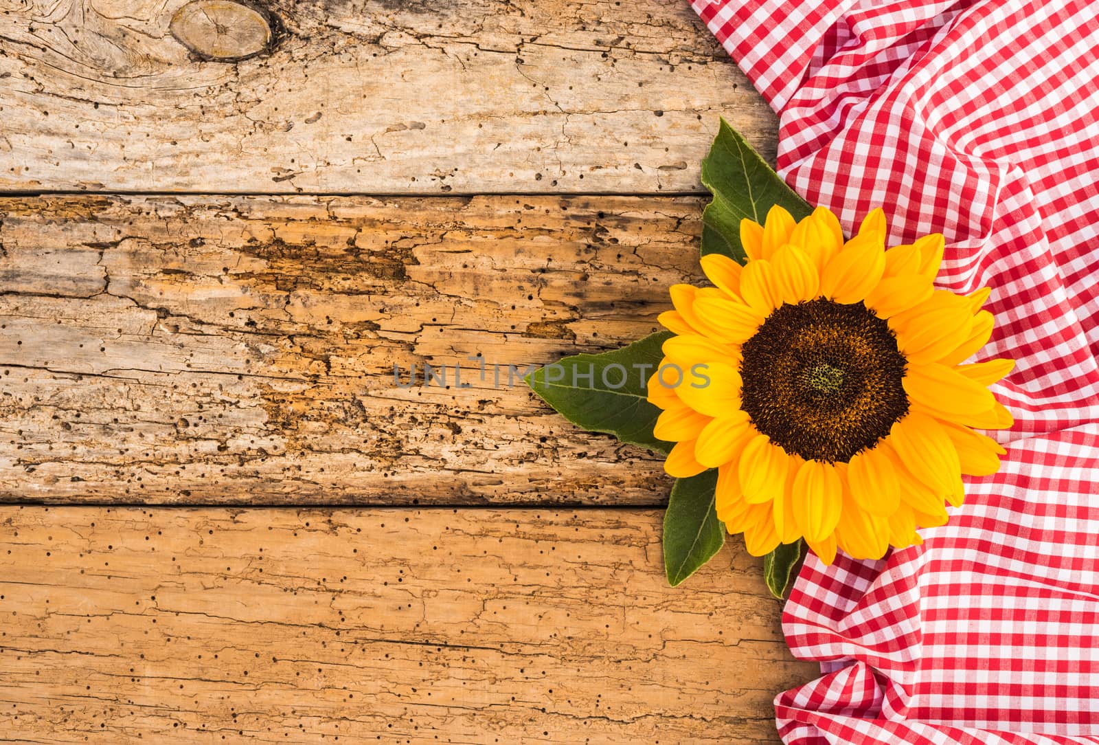 Sunflower decoration with red tablecloth on old wooden background with copy space