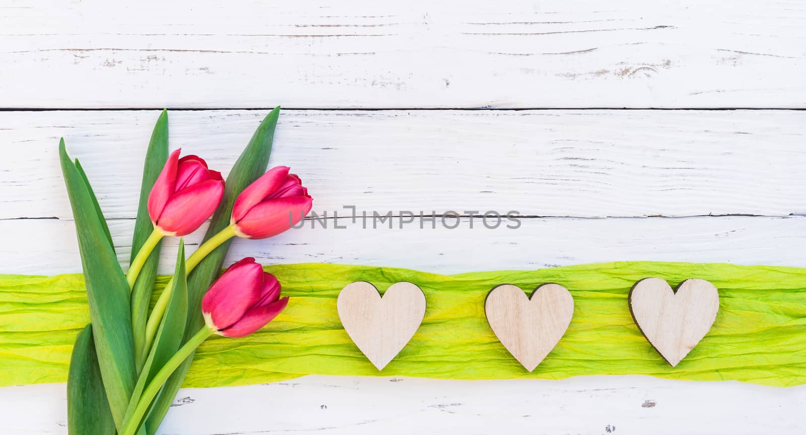 Romantic love background with red flowers and hearts frame on white wood