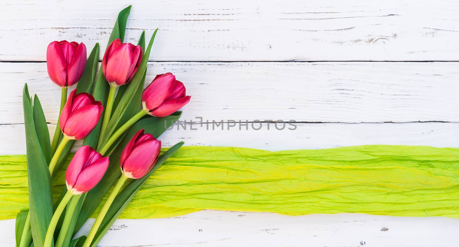 Red spring flowers bouquet with tulips on white wooden background and copy space