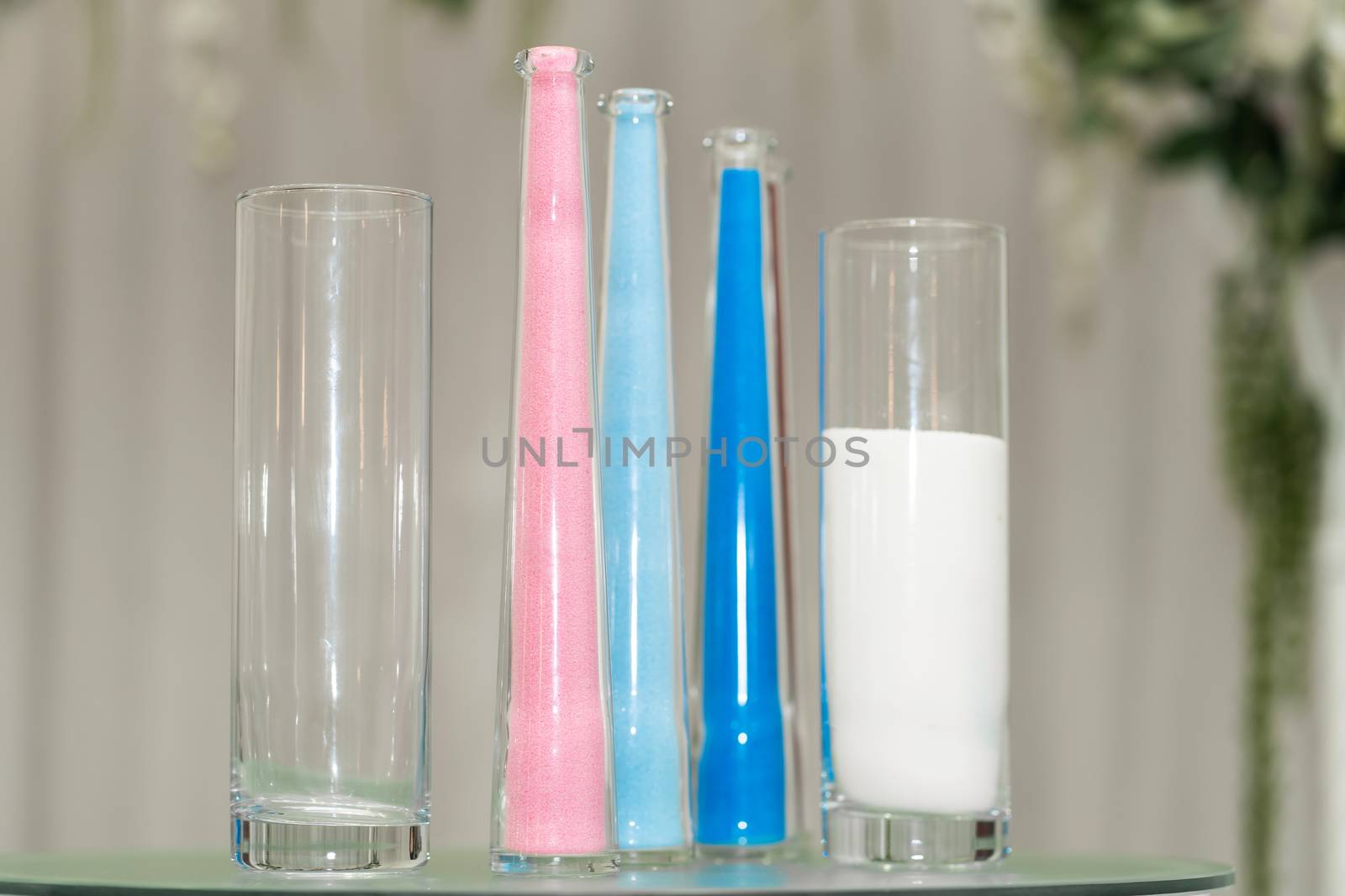 Stylish decorative glass colored vases for fresh flowers decorating the festive table