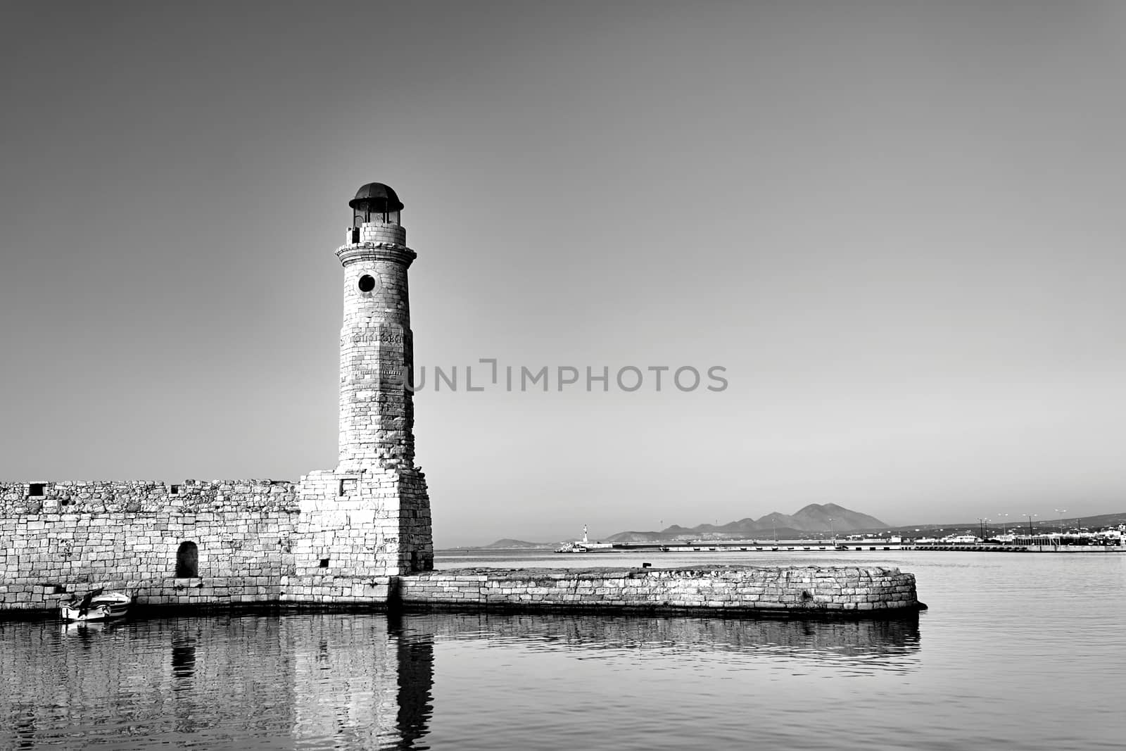 stone wall and historic lighthouse in the port of Rethymnon on the island of Crete, black and white