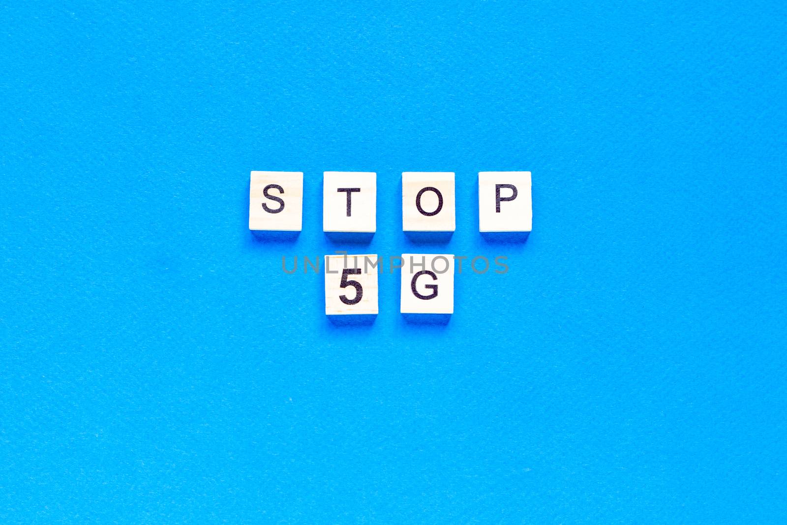 stop 5 g. 5 G. Five G's, written in wooden letters on a blue background. Flat layout. Wireless network. New technology. top view.