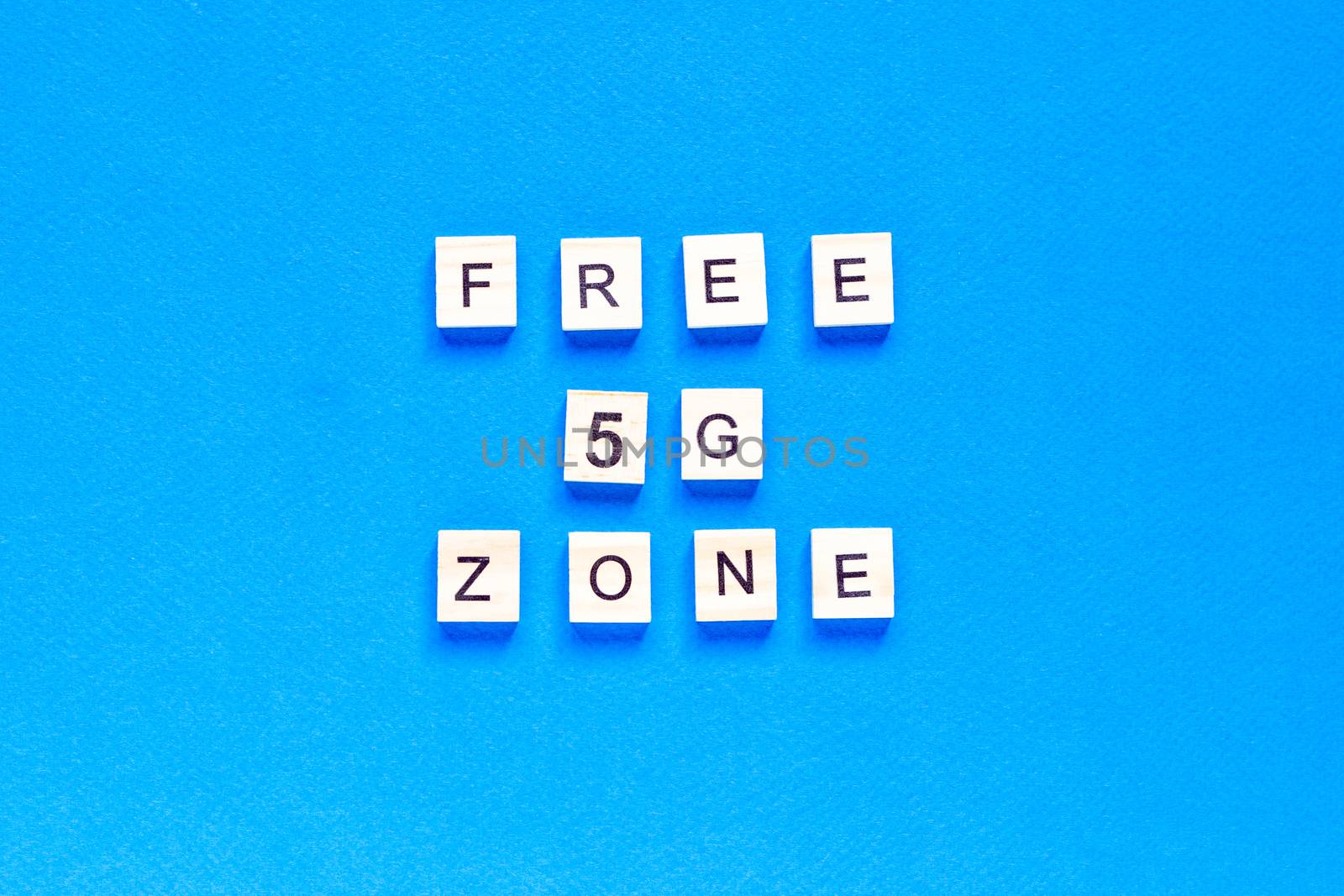 free 5 g zone. 5 G. Five G's, written in wooden letters on a blue background. top view. Flat layout. Wireless network. New technology. by Pirlik