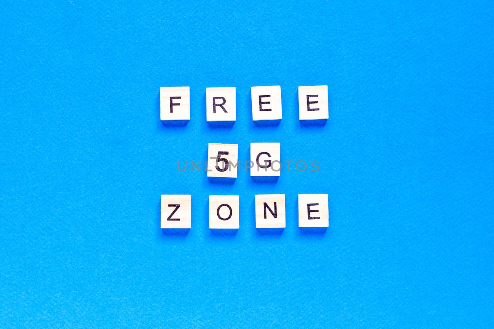 free 5 g zone. 5 G. Five G's, written in wooden letters on a blue background. Flat layout. Wireless network. New technology. top view.