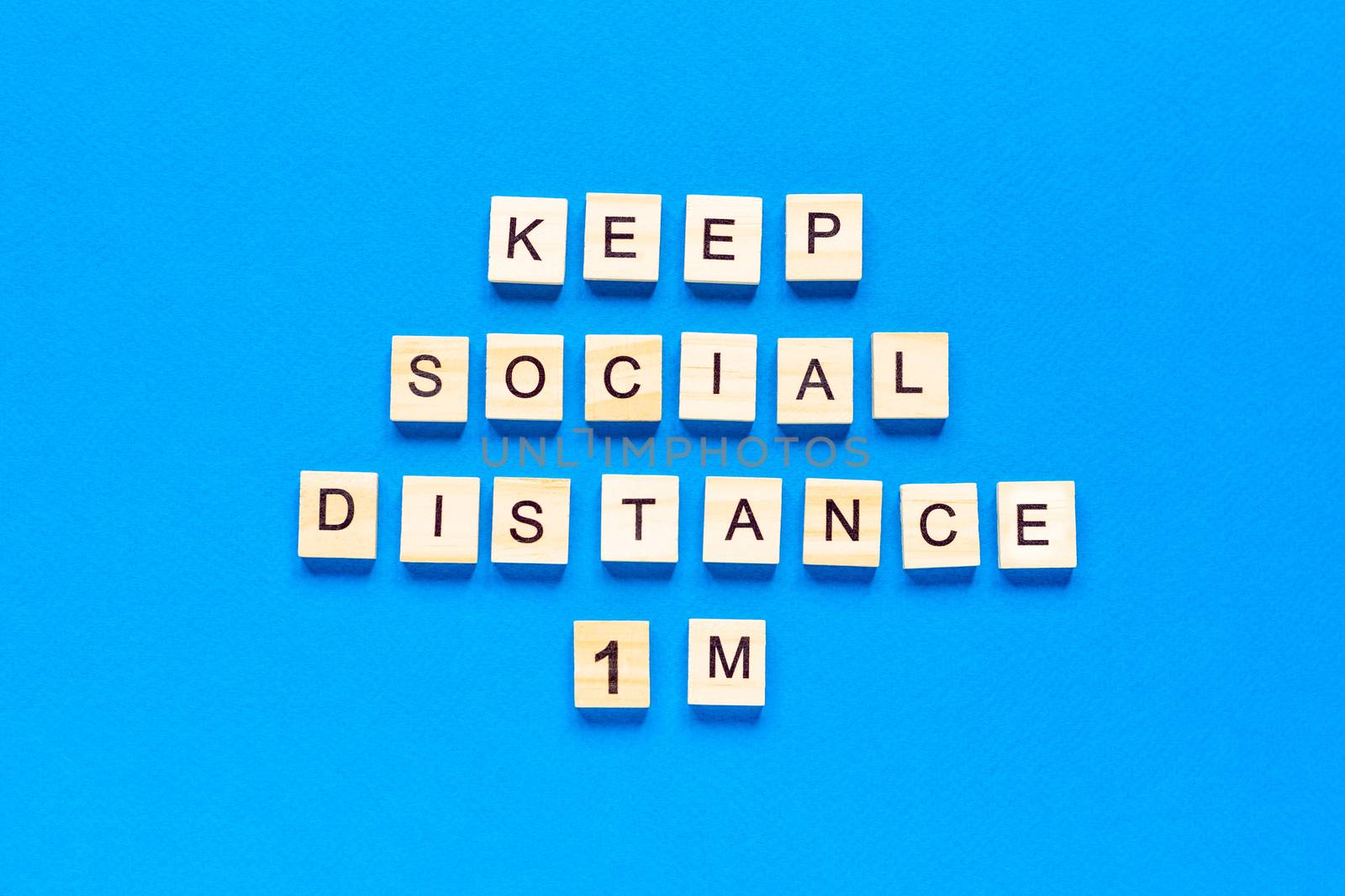 Words keep social distance 1 m. Wooden inscription on a blue background. Information sign of keep social distance 1 m from blocks. flat layout