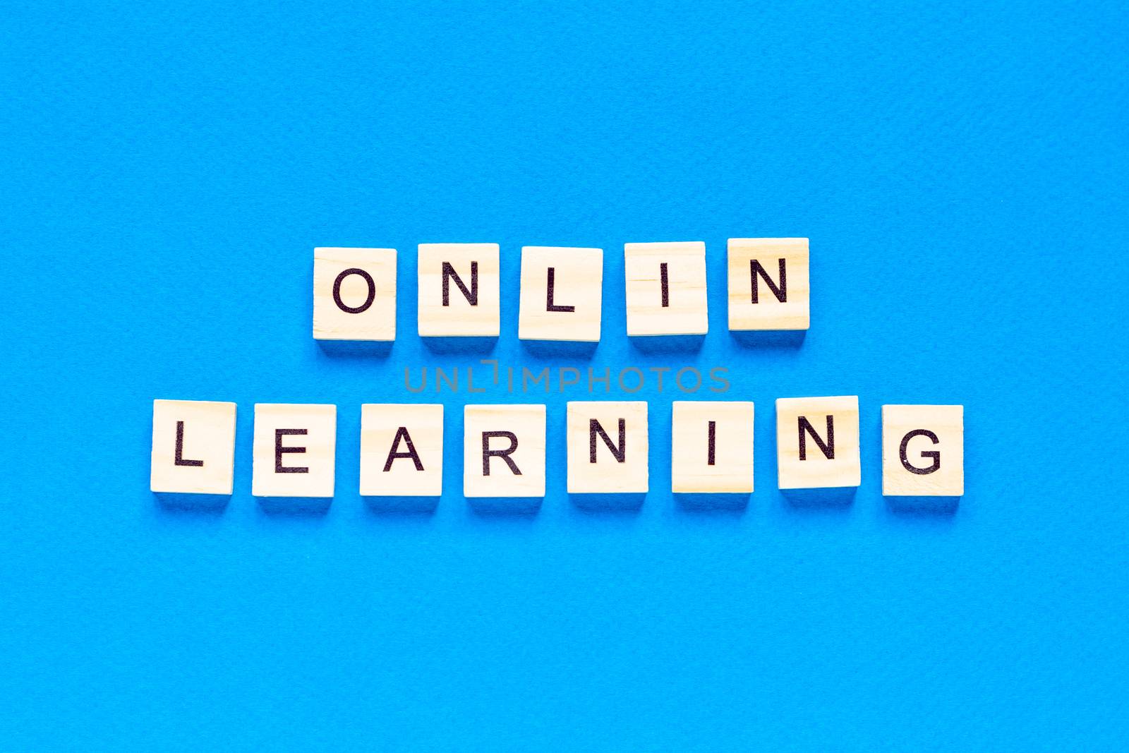 online learning concepts written in wooden letters on a blue background. a top view of a flat layout, a new form of learning, online school by Pirlik