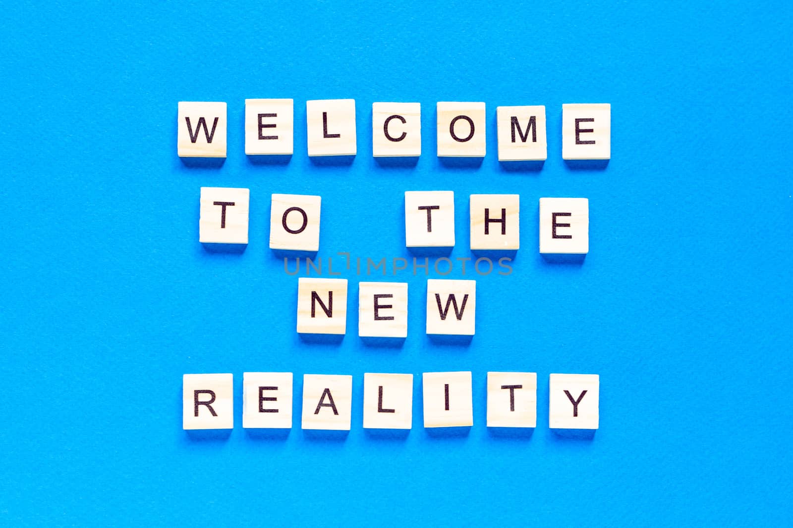 the inscription welcome to the new reality in wooden letters on a blue background. the view from the top. Modern technologies, a new device of the world