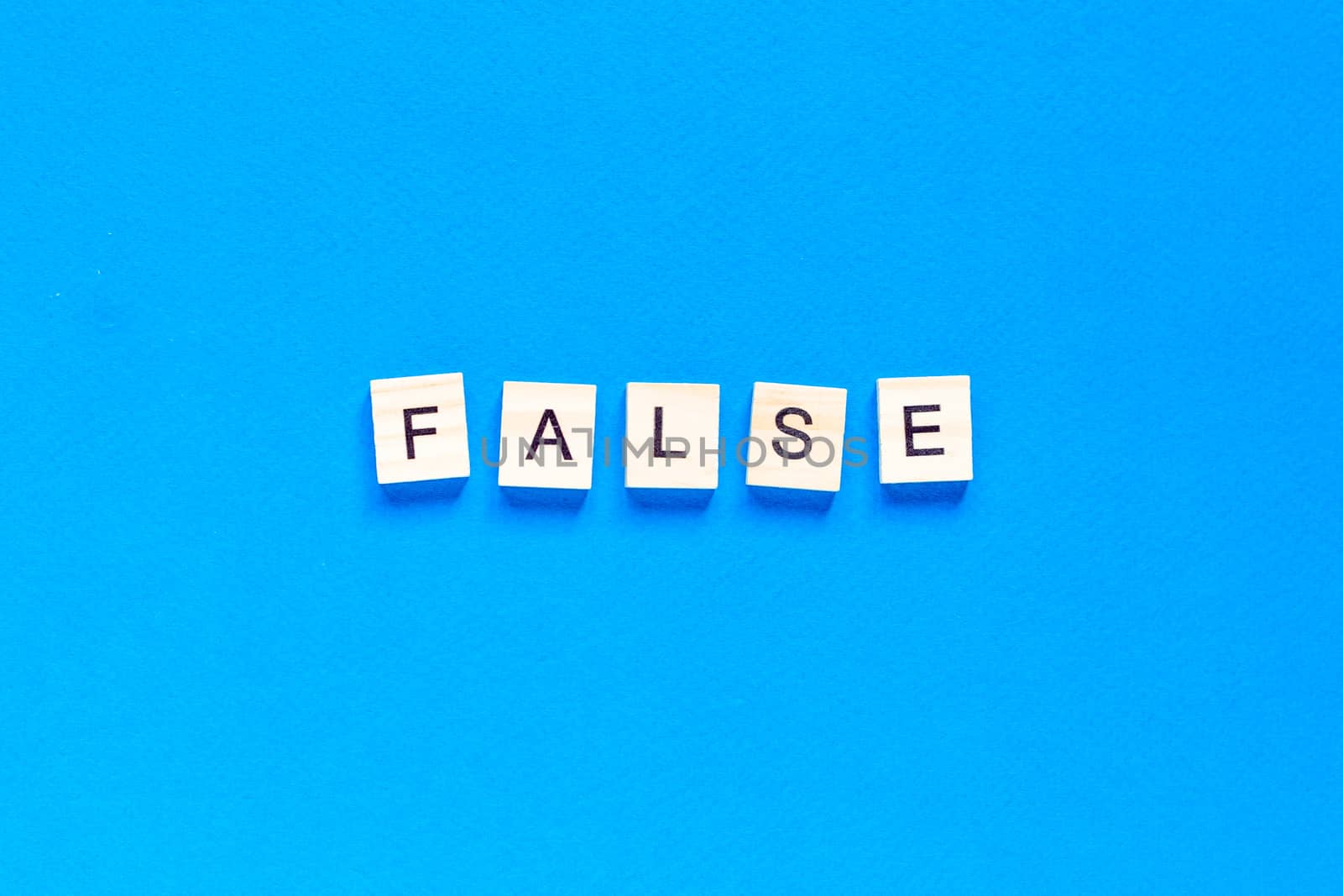 FALSE word alphabet letters on blue background. flat layout. top view.