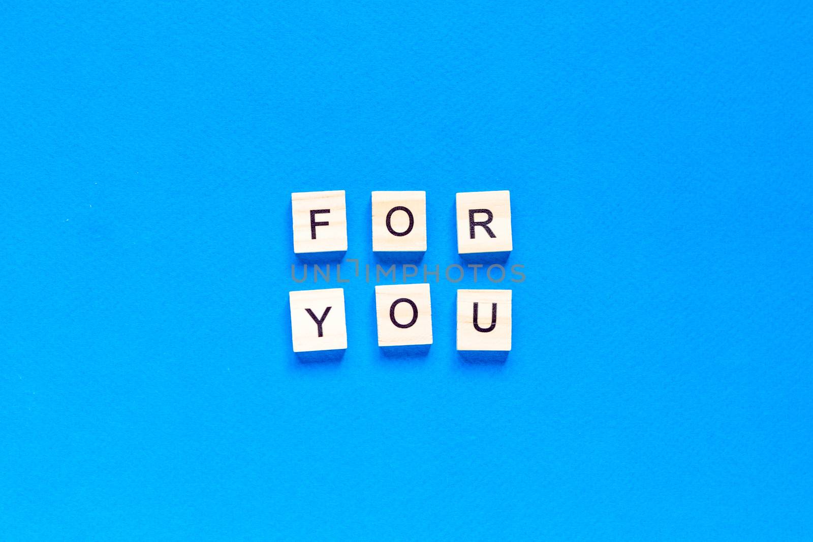 FOR YOU written in wooden letters on a blue background. top view, flat layout, this is all for you by Pirlik