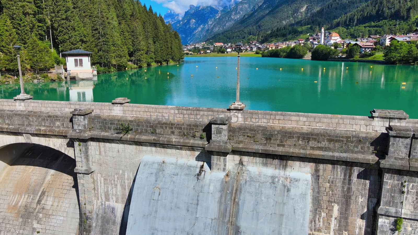 Alpin lake and dam in summertime, view from drone, Auronzo, italian dolomites.