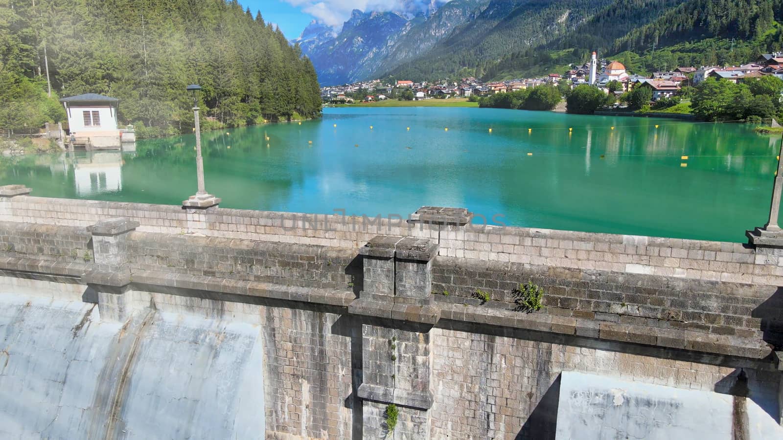 Alpin lake and dam in summertime, view from drone, Auronzo, italian dolomites.