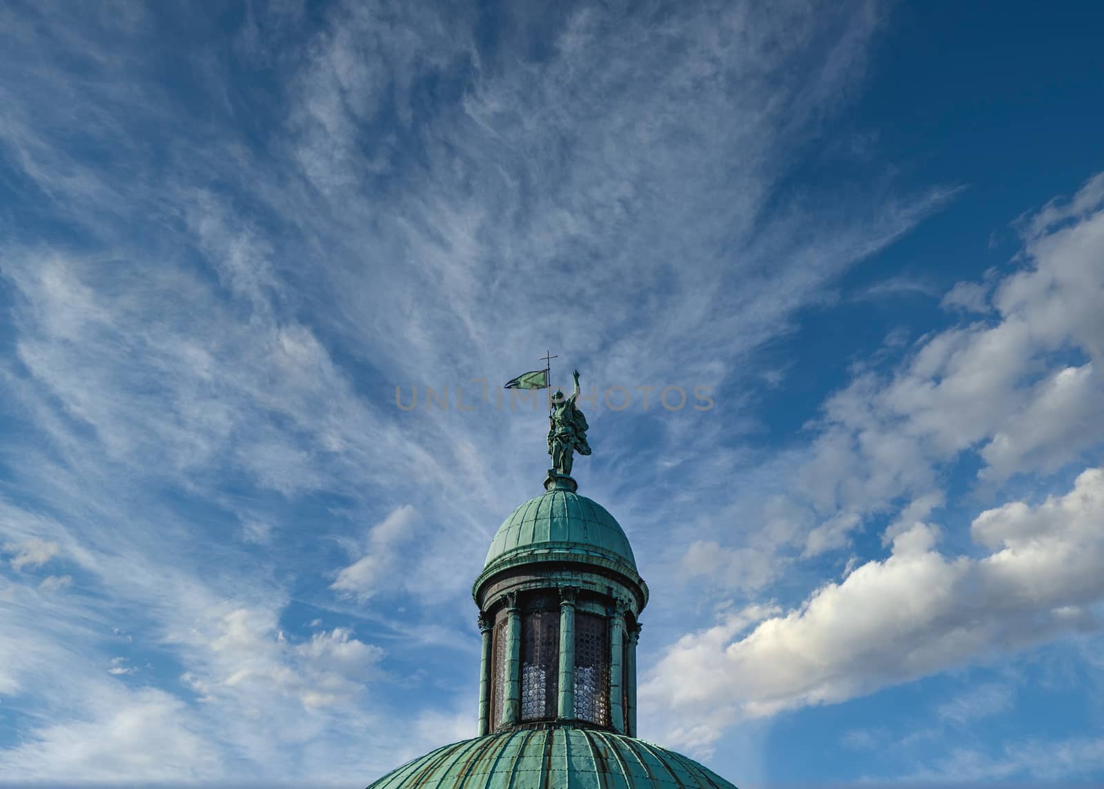 Old Statue on Green Cupola Against Blue Sky