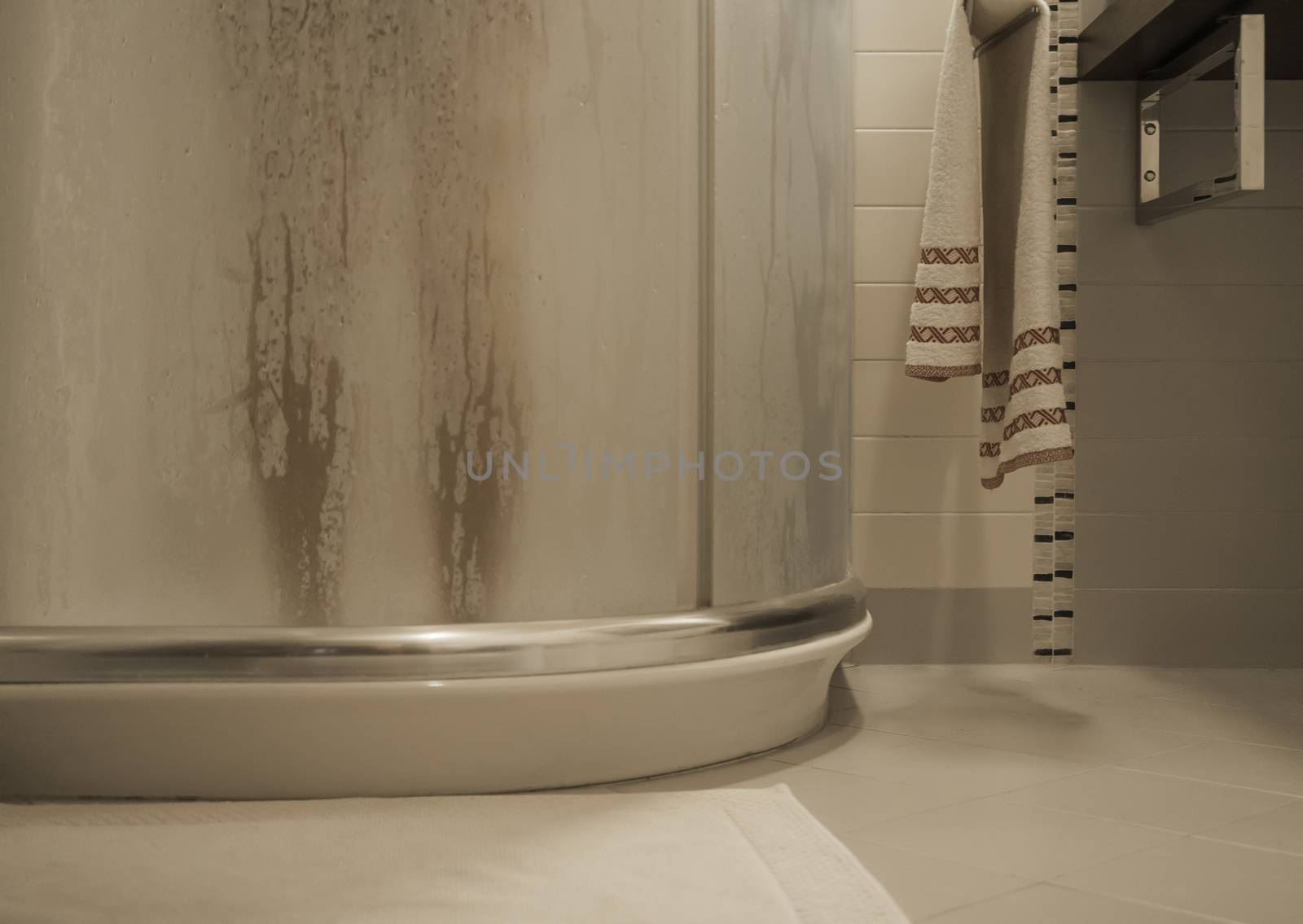 Sexy naked woman's legs inside the shower cabin behind the fogged glass door in her modern design bathroom by robbyfontanesi