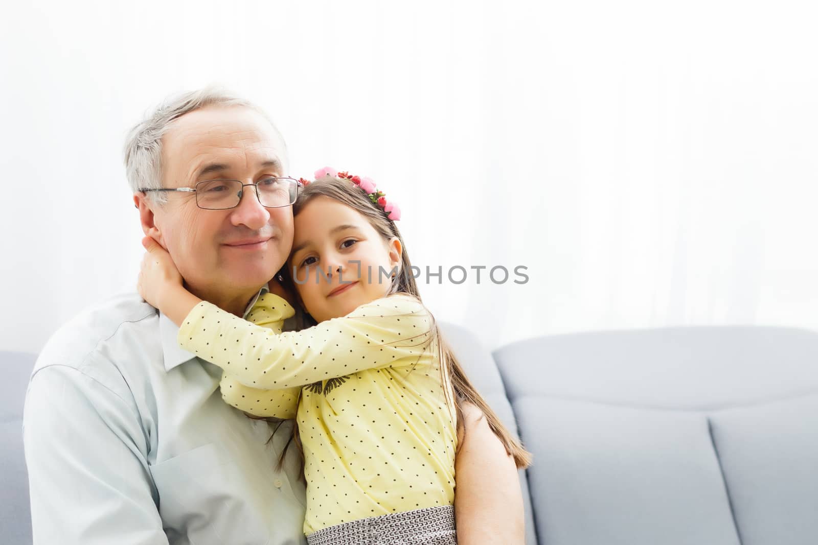 Funny lifestyle portrait of grandchild embracing grandfather by Andelov13