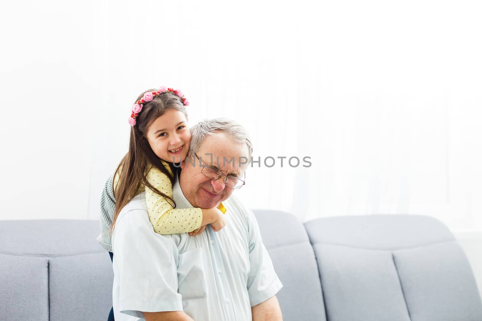 Funny lifestyle portrait of grandchild embracing grandfather