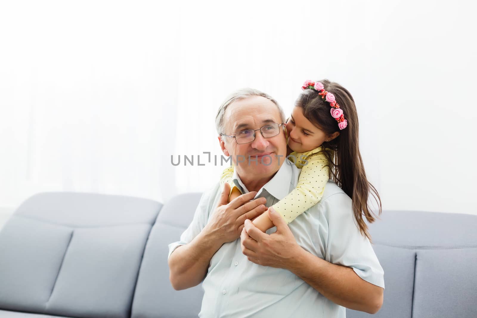 Funny lifestyle portrait of grandchild embracing grandfather