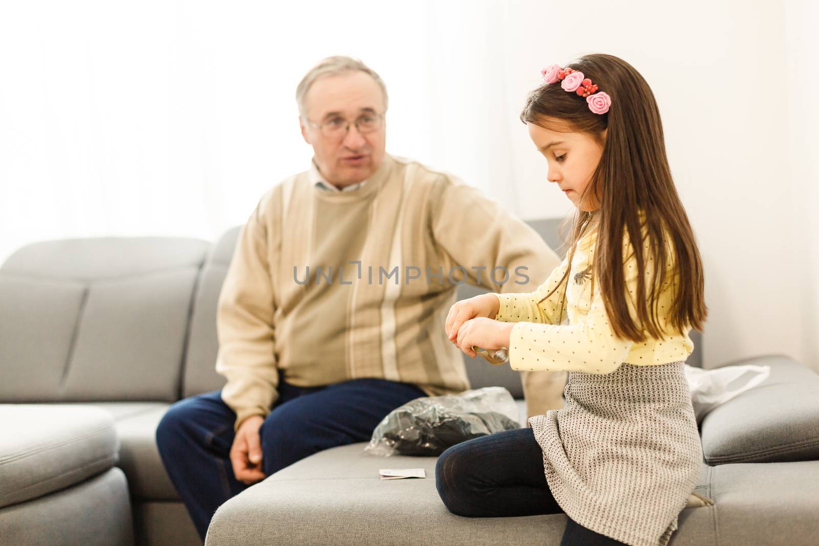 The happy girl a grandfather on the sofa