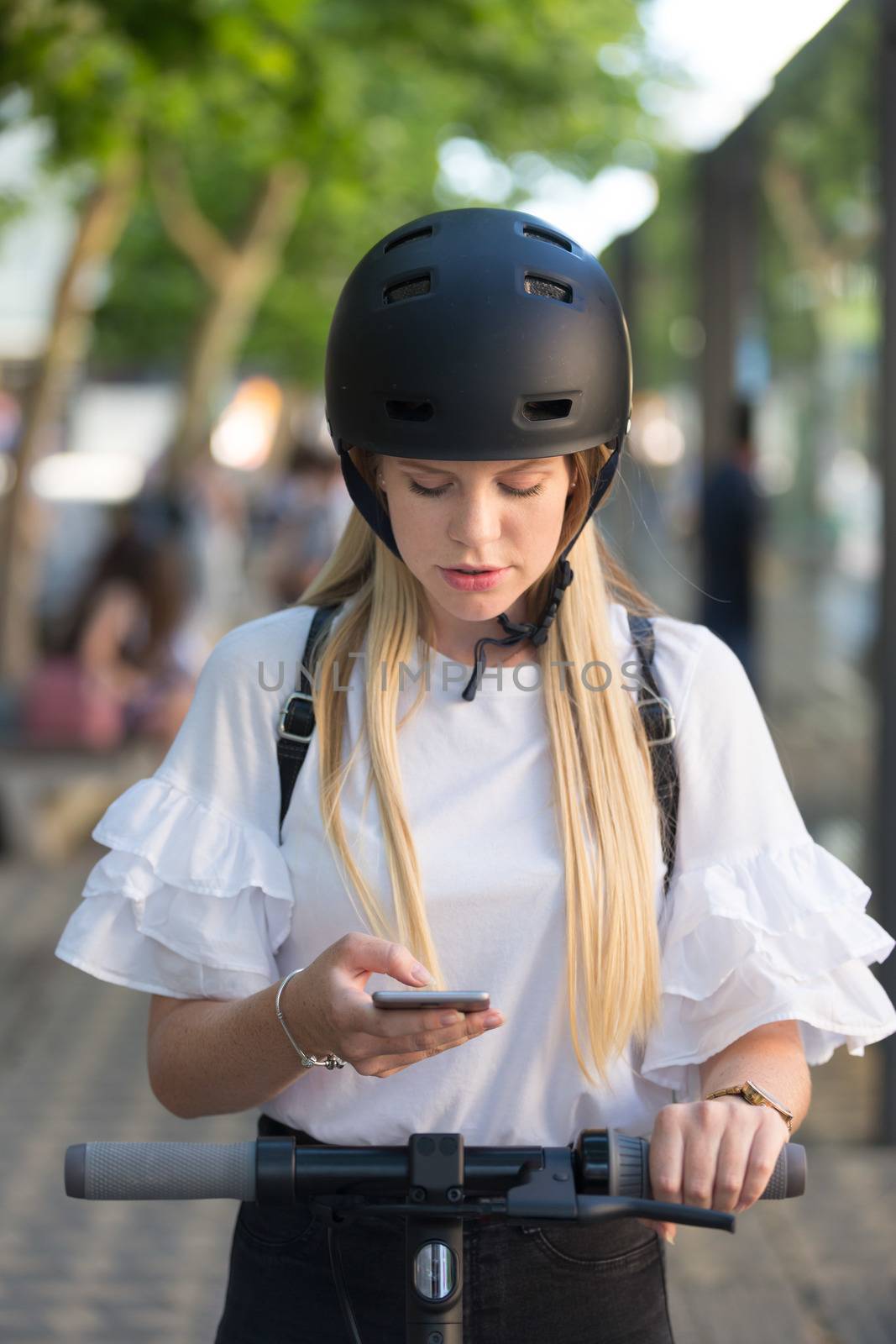 Woman using smartphone and renting modern electric scooter with an application. Urban transport concept by kasto
