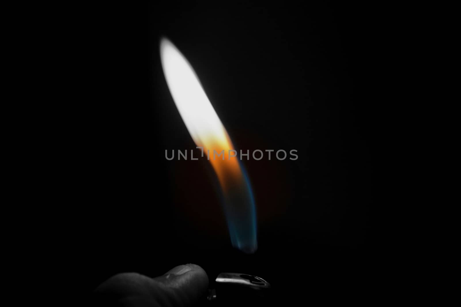 A hand lighting up a lighter on a black background by rkbalaji