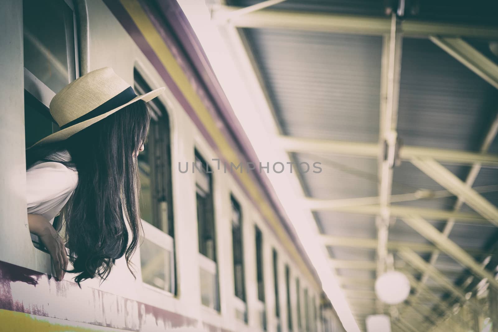 Asian woman traveler has get in the train with happiness at Hua Lamphong station at Bangkok, Thailand.