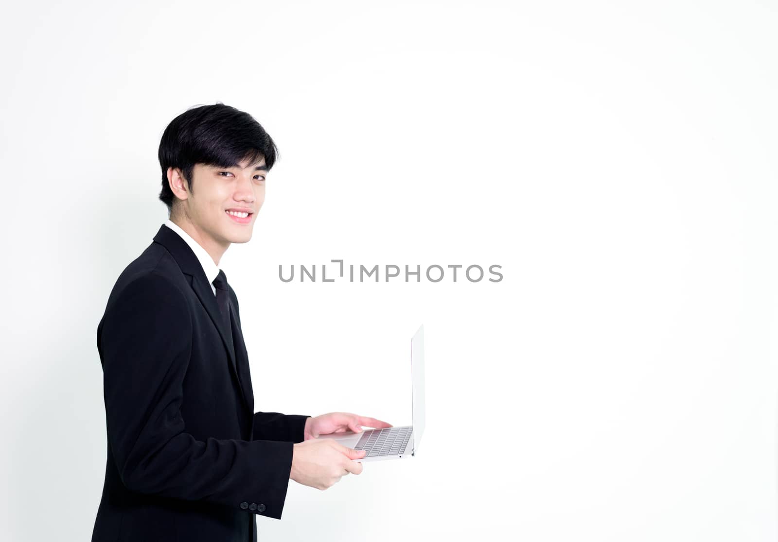 Asian business handsome man has holding laptop for woking with h by animagesdesign