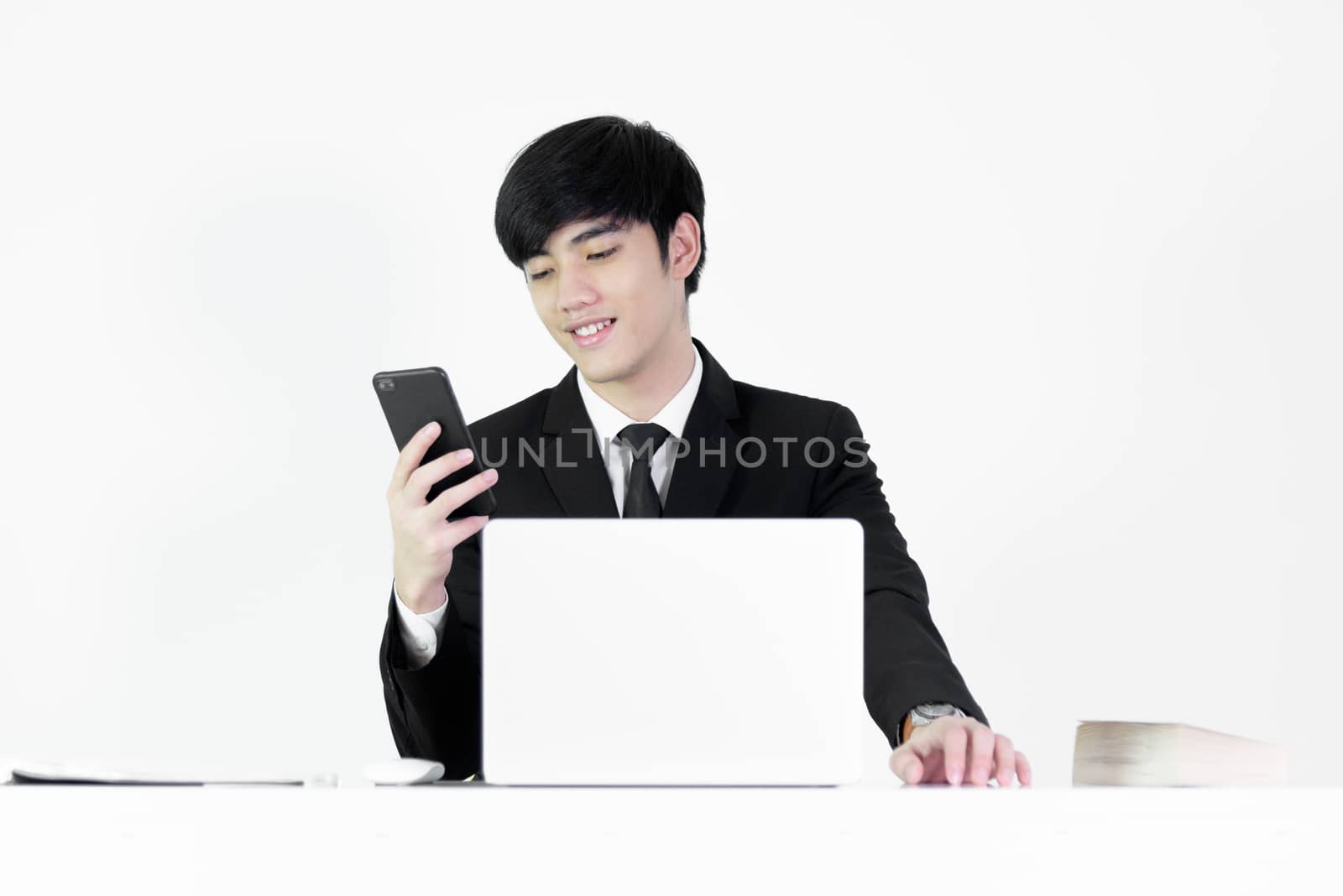 Asian manager businessman sitting at desk and using with phone, isolated on white background.