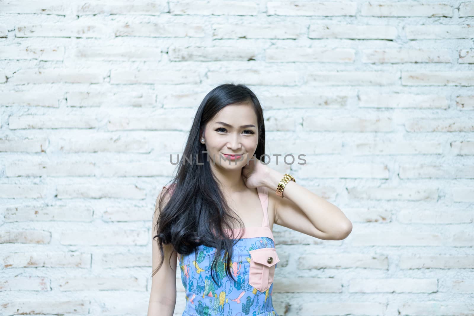 Asian pretty girl has posing hipster concept with brick background at Little Tree Garden cafe, Nakhon Pathom province, Thailand in the morning.