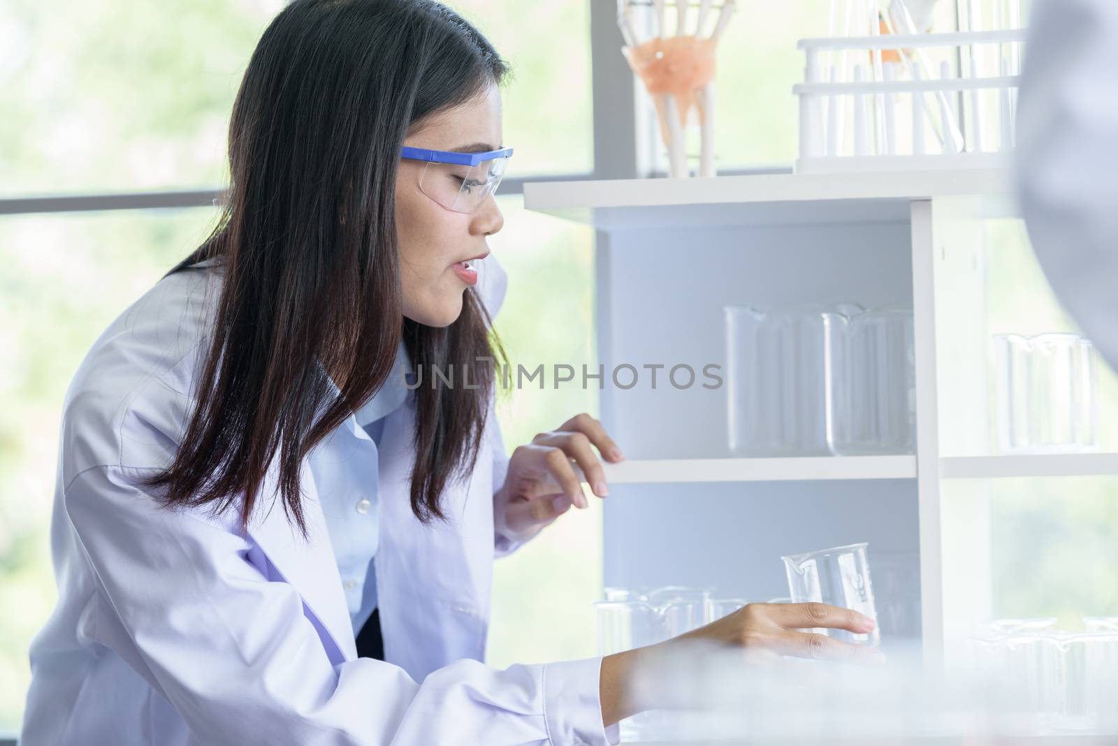 Asian young girl student scientist researching  and learning in a laboratory.