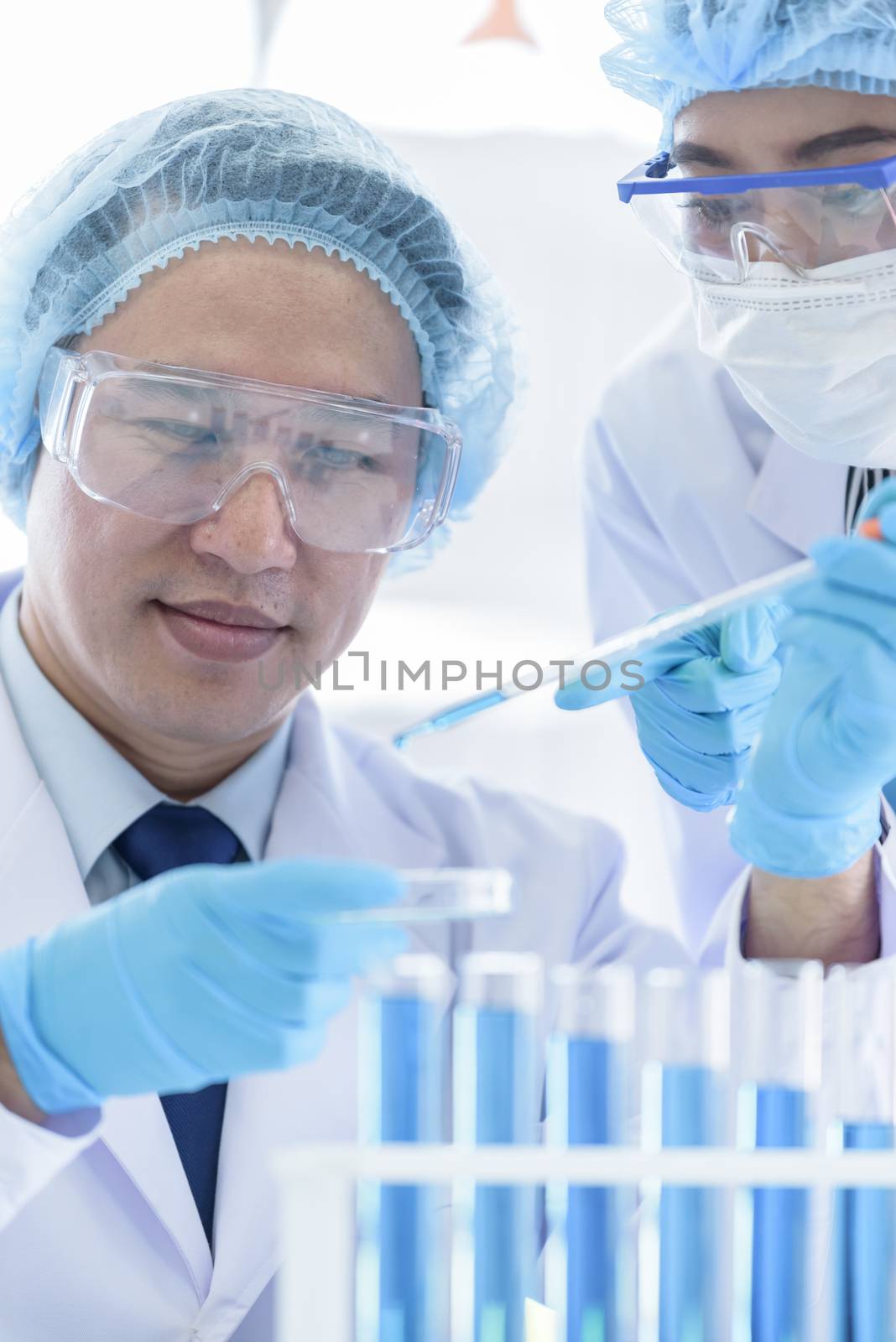 Asian senior scientist have teaching young student scientist in a laboratory.