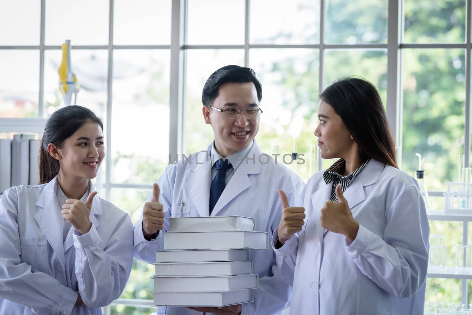 Senior asian scientist has assigning new job to students in laboratory with happiness.