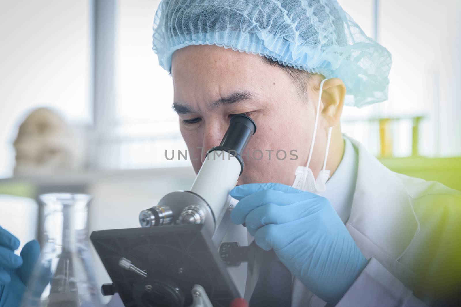 Asian man scientist researching  and learning in a laboratory.